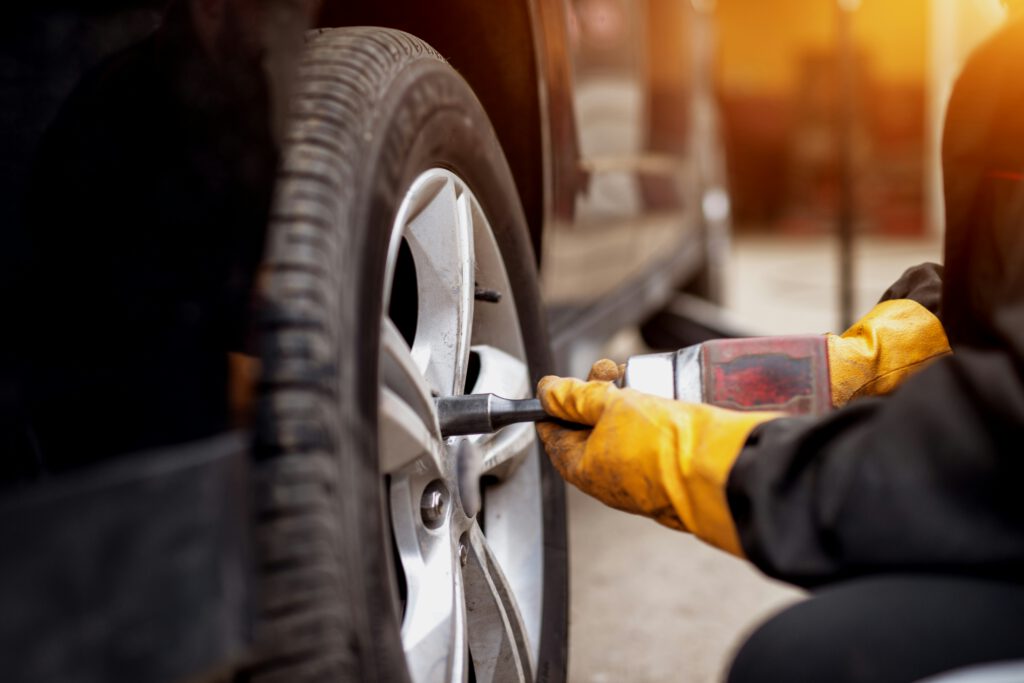 Mecánico trabajando en la rueda de un coche con llave de impacto